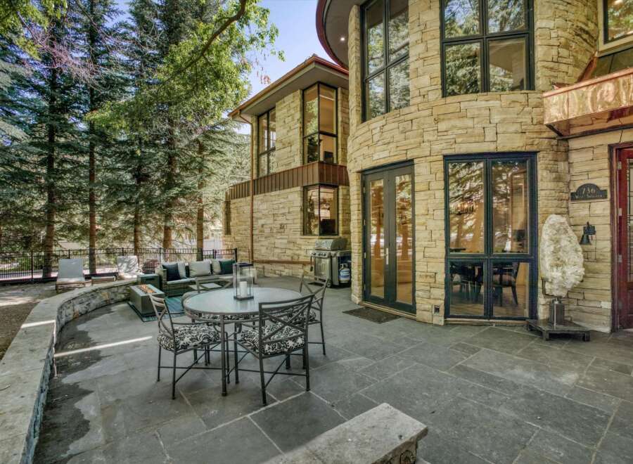 Experience luxurious outdoor living with this stunning patio featuring a round dining table and chairs, perfect for al fresco meals.