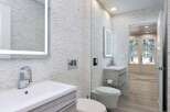 Experience modern luxury in this stunning bathroom, featuring sleek vanities and a striking stacked stone accent wall.