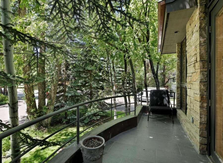 Enjoy the serene outdoors from this charming balcony, offering a peaceful retreat amidst lush greenery.