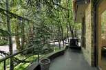 Enjoy the serene outdoors from this charming balcony, offering a peaceful retreat amidst lush greenery.