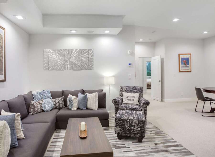 Experience comfort and style in this inviting living space, featuring a spacious sectional sofa adorned with decorative pillows and a modern coffee table.