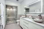 Experience modern luxury in this stunning bathroom featuring a spacious walk-in shower with sleek tile work and a built-in bench.