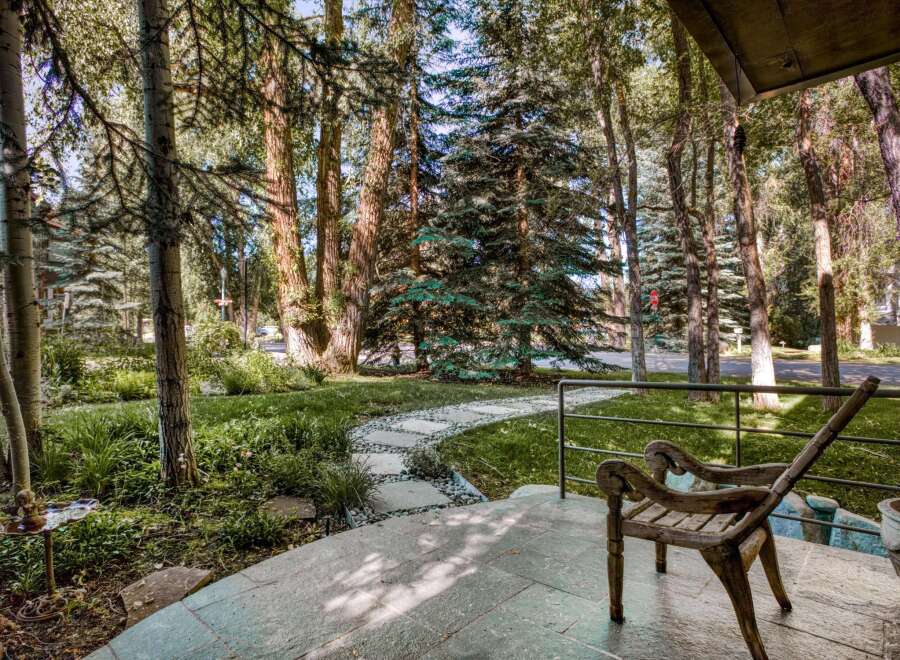 Step onto the inviting porch of this charming property, where a rustic wooden chair awaits.