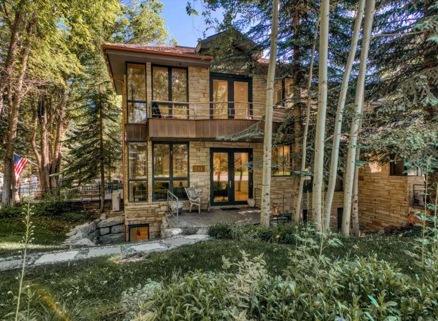 Nestled amidst lush greenery and mature trees, this stunning stone-clad residence offers a serene retreat.