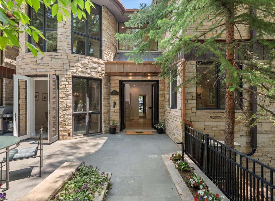Experience luxury living in this stunning stone-clad residence featuring a grand entrance with double doors and expansive windows that flood the interior with natural light.