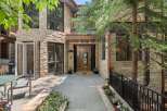 Experience luxury living in this stunning stone-clad residence featuring a grand entrance with double doors and expansive windows that flood the interior with natural light.