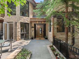Experience luxury living in this stunning stone-clad residence featuring a grand entrance with double doors and expansive windows that flood the interior with natural light.
