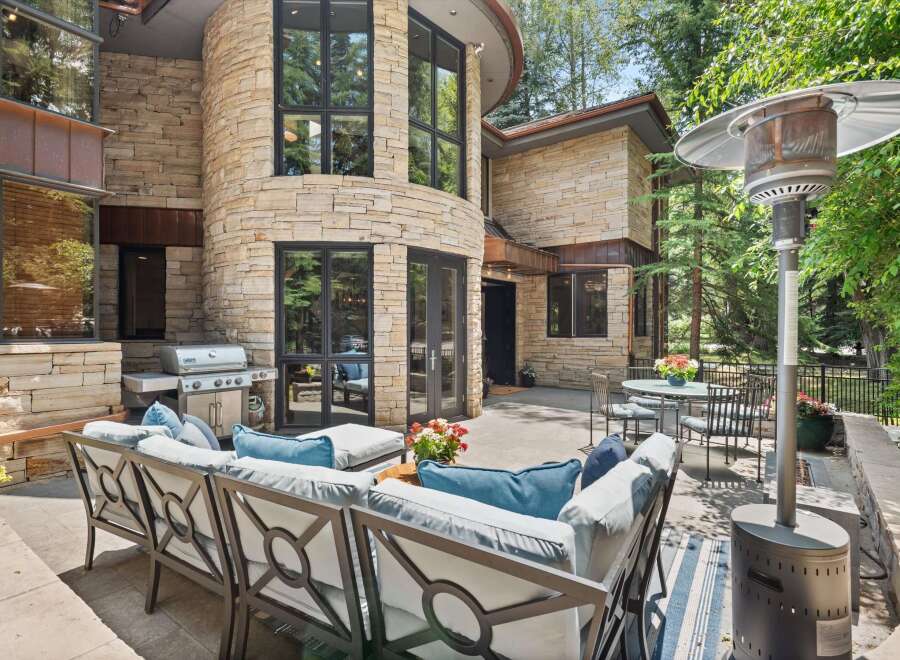 Enjoy outdoor living with this spacious patio featuring a built-in grill and comfortable seating.