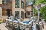 Enjoy outdoor living with this spacious patio featuring a built-in grill and comfortable seating.
