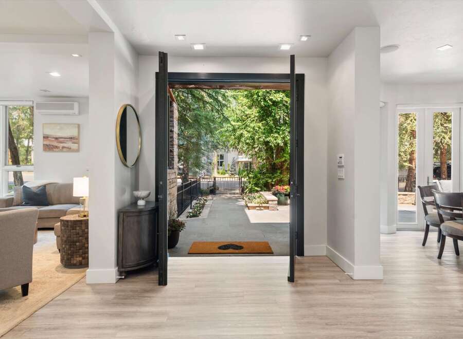 Step into this stunning entryway, where an open-concept design seamlessly connects the interior living spaces with the lush outdoor patio.