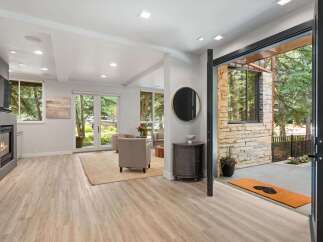 Step into this inviting living space featuring a modern fireplace and elegant hardwood floors.