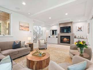 Experience modern living in this beautifully appointed living room, featuring a cozy fireplace and a large television for entertainment.