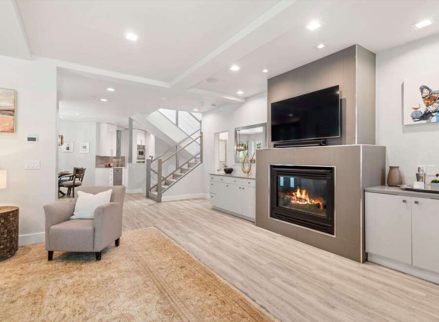 Experience modern living in this spacious open-concept home, featuring a sleek gas fireplace as the centerpiece of the living area.