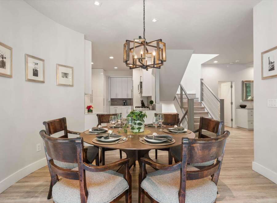 This elegant dining room features a round wooden table set for six, perfect for intimate gatherings.