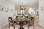 This elegant dining room features a round wooden table set for six, perfect for intimate gatherings.