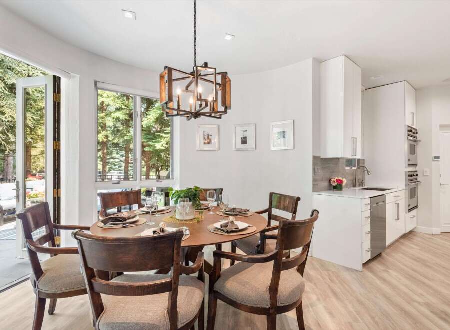Experience elegant dining with this beautifully set round table, featuring dark wood chairs with upholstered seats.