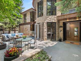 Experience luxurious outdoor living with this stunning patio featuring a comfortable sectional sofa, dining set, and a modern fire pit.