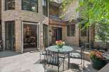 Enjoy outdoor living with this charming patio featuring a glass-top dining table and chairs, perfect for al fresco meals.
