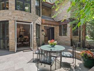 Enjoy outdoor living with this charming patio featuring a glass-top dining table and chairs, perfect for al fresco meals.