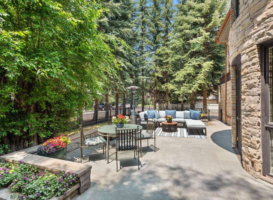 Enjoy outdoor living in this stunning patio space, featuring a comfortable sectional sofa, a dining set, and a gas heater for cooler evenings.