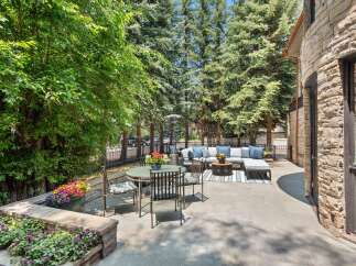 Enjoy outdoor living in this stunning patio space, featuring a comfortable sectional sofa, a dining set, and a gas heater for cooler evenings.