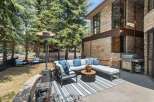 Enjoy outdoor living with this spacious patio featuring a comfortable sectional sofa, a round coffee table, and a propane heater for cooler evenings.