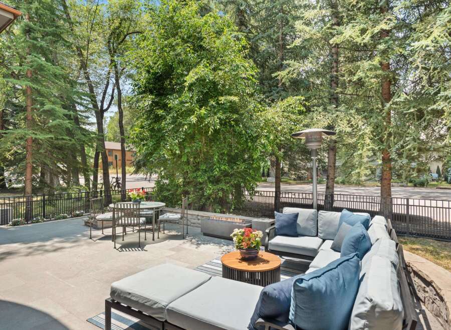Enjoy outdoor living at its finest on this spacious patio, complete with a comfortable sectional sofa and a modern fire pit.