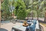 Enjoy outdoor living at its finest on this spacious patio, complete with a comfortable sectional sofa and a modern fire pit.