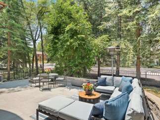 Enjoy outdoor living at its finest on this spacious patio, complete with a comfortable sectional sofa and a modern fire pit.