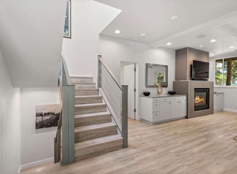 Step into this beautifully renovated home featuring a modern open-concept living space with a cozy fireplace and a sleek entertainment center.
