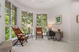 This bright and airy room features large bay windows offering stunning views of the surrounding trees.