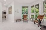Experience natural light and serene views in this inviting room, featuring large windows that overlook lush greenery.