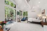 Experience serene living in this luxurious bedroom featuring a spacious king-sized bed and a comfortable chaise lounge, perfect for relaxation.