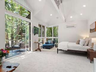 Experience serene living in this luxurious bedroom featuring a spacious king-sized bed and a comfortable chaise lounge, perfect for relaxation.
