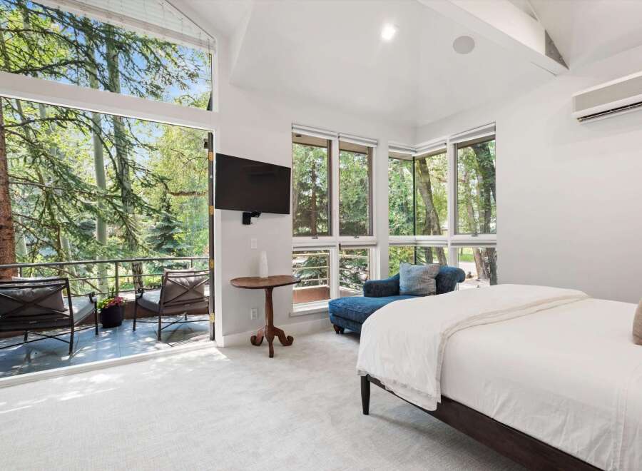 Experience luxurious living with this stunning bedroom featuring a spacious king-sized bed and a comfortable chaise lounge.