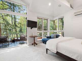 Experience luxurious living with this stunning bedroom featuring a spacious king-sized bed and a comfortable chaise lounge.