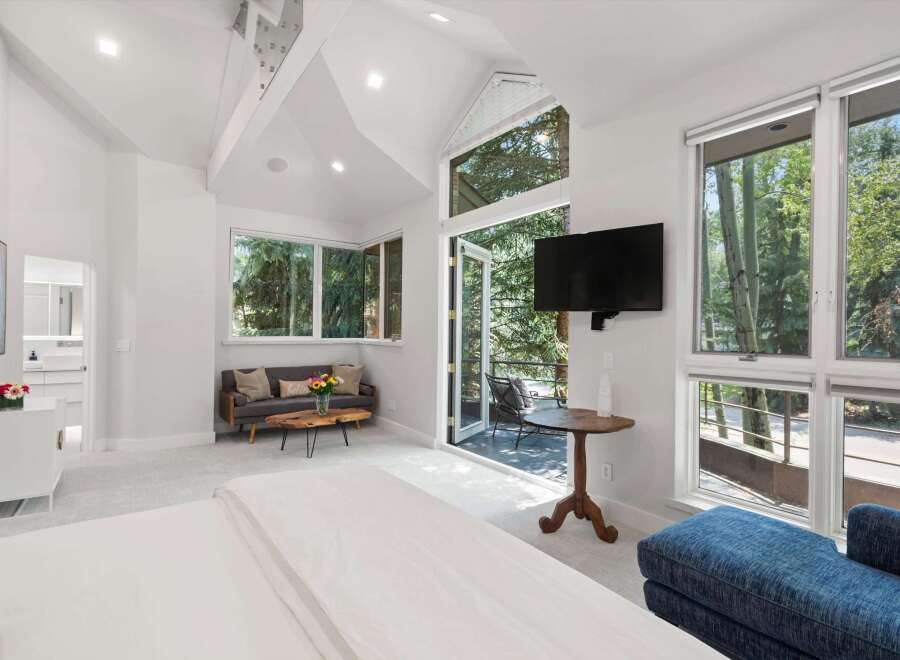 Experience luxurious living in this spacious bedroom featuring a vaulted ceiling and abundant natural light.