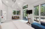Experience luxurious living in this spacious bedroom featuring a vaulted ceiling and abundant natural light.