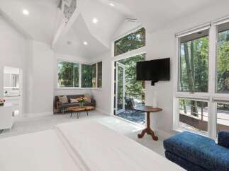 Experience luxurious living in this spacious bedroom featuring a vaulted ceiling and abundant natural light.