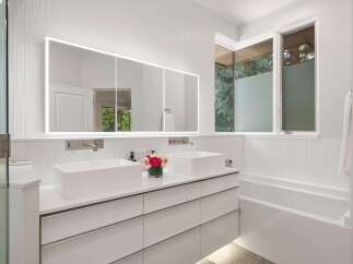 Experience modern luxury in this stunning bathroom featuring a spacious double vanity with vessel sinks and sleek faucets.