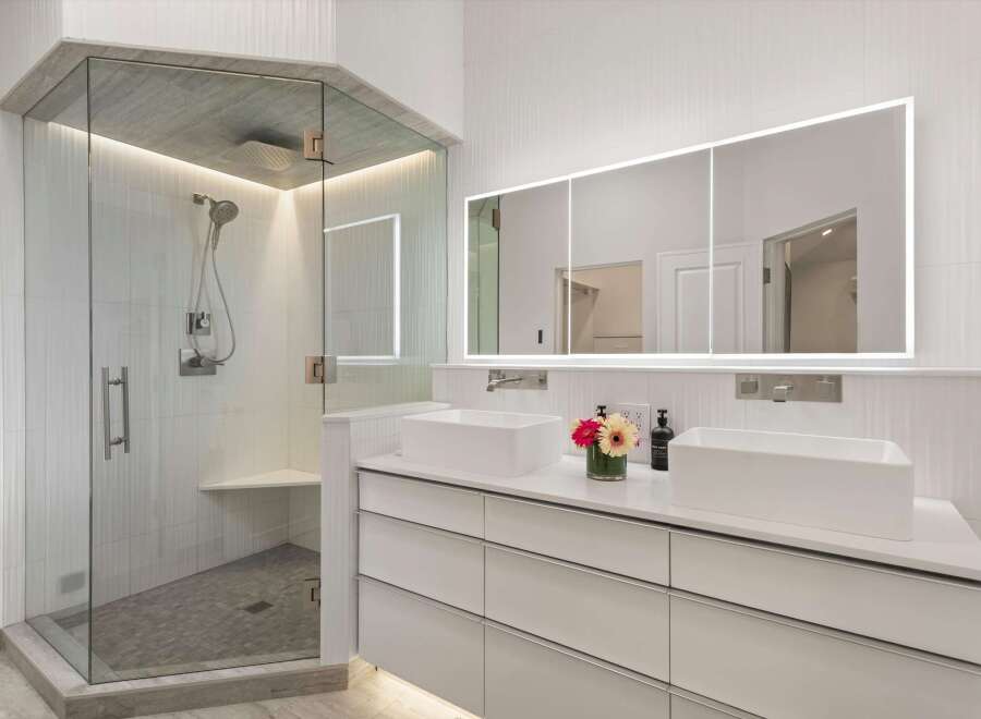 Experience luxury in this modern bathroom featuring a spacious glass-enclosed shower with a rainfall showerhead and elegant tilework.