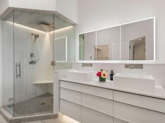 Experience luxury in this modern bathroom featuring a spacious glass-enclosed shower with a rainfall showerhead and elegant tilework.
