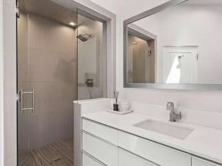 Experience modern luxury in this stunning bathroom featuring a spacious walk-in shower with elegant tilework and a sleek glass enclosure.
