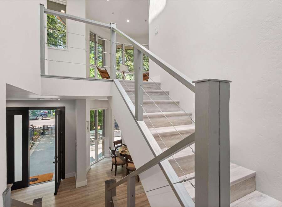 Experience modern living in this stunning home featuring a striking open-concept staircase with sleek cable railings.