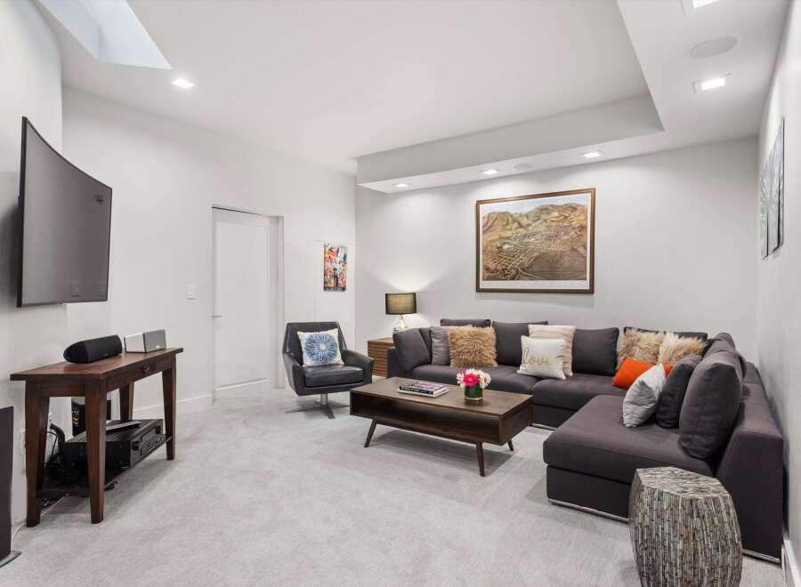 Experience ultimate relaxation in this modern living room, featuring a plush sectional sofa adorned with decorative pillows and a stylish coffee table.