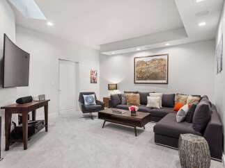 Experience ultimate relaxation in this modern living room, featuring a plush sectional sofa adorned with decorative pillows and a stylish coffee table.