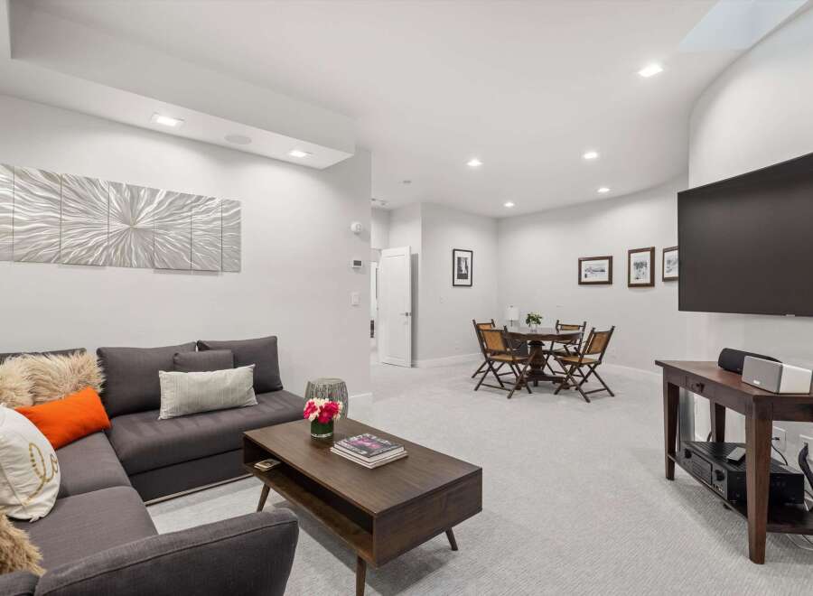 This spacious living area features a comfortable sectional sofa adorned with decorative pillows, perfect for relaxing.