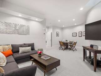 This spacious living area features a comfortable sectional sofa adorned with decorative pillows, perfect for relaxing.