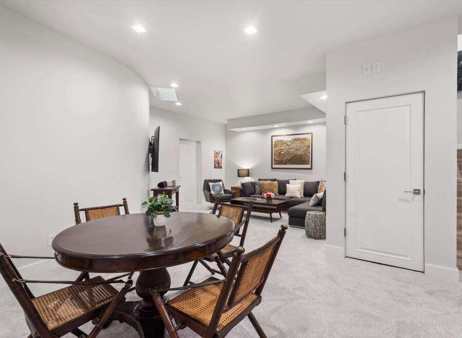 This inviting basement living area features a cozy sectional sofa adorned with plush pillows, perfect for relaxing evenings.