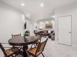 This inviting basement living area features a cozy sectional sofa adorned with plush pillows, perfect for relaxing evenings.